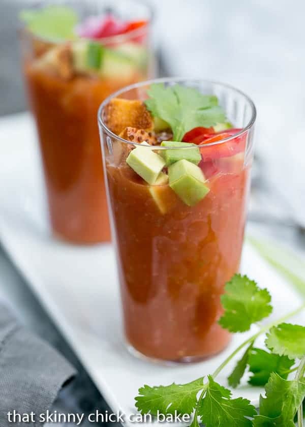 Gazpacho Shooters on a white tray with vegetable garnishes