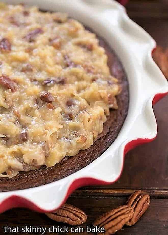 German Chocolate Brownie Pie in a ruffle edged pie plate with pecan halves