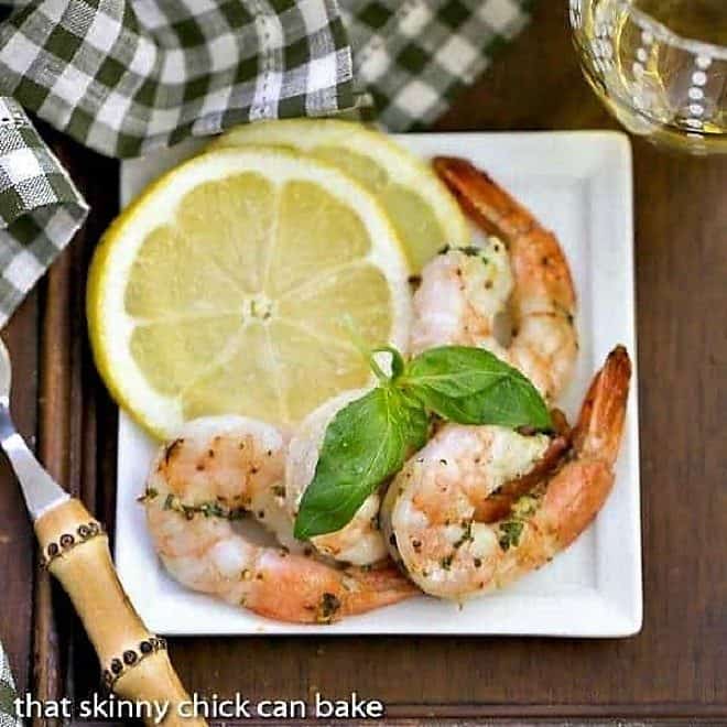 Grilled Shrimp Scampi - A phenomenal shrimp dish cooked on the BBQ Grilled Shrimp Scampi on a square white plate with basil and lemon slices
