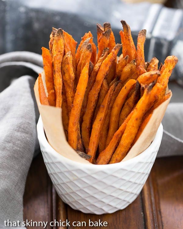 Spicy Sweet Potato Fries standing upright in a white ceramic bowl.