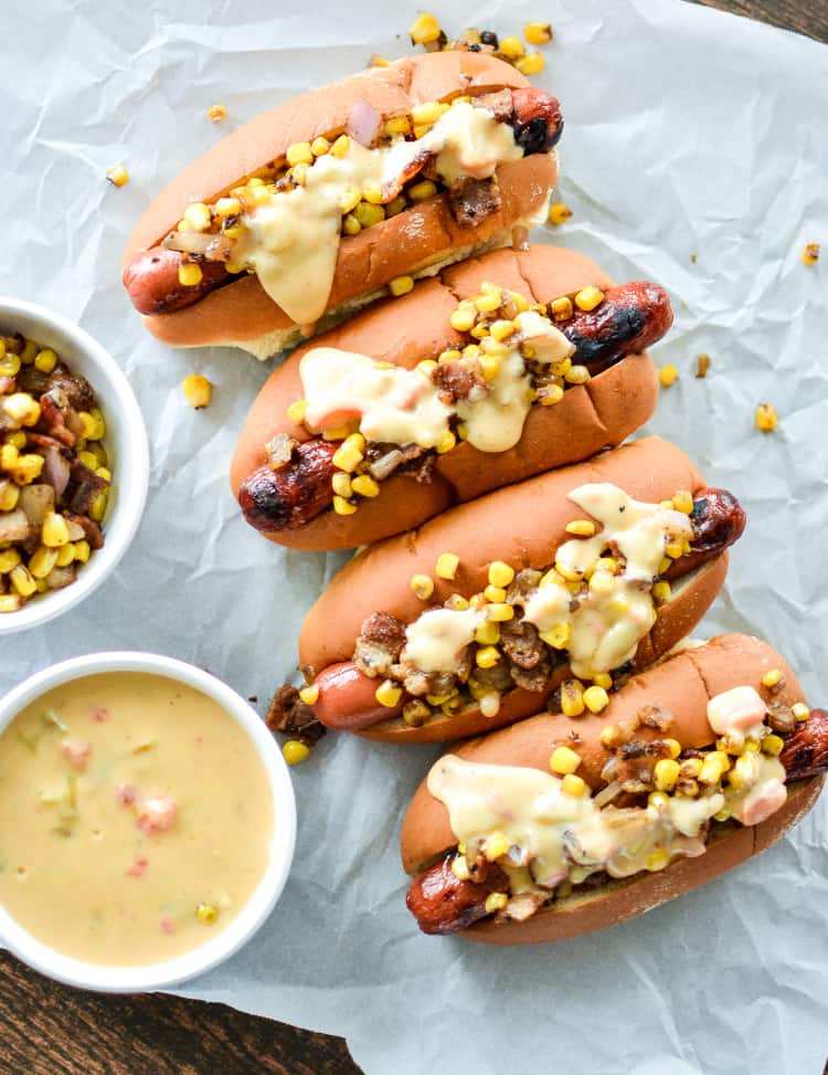 Hot dogs with chipotle cheese sauce on some crumpled parchment paper