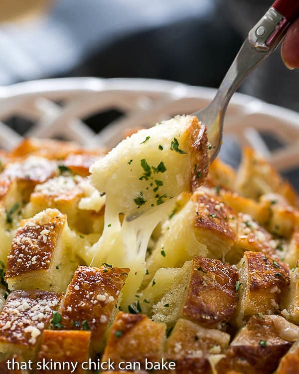 Cheesy Garlic Bread with a fork full of gooey bread on a fork.