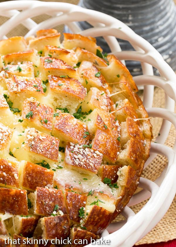 Close up view of Cheesy Garlic Bread in a white ceramic basket.