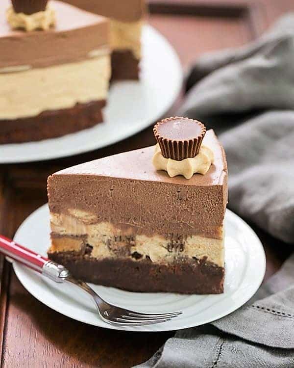 Peanut Butter Chocolate Mousse Cake slice on a white dessert plate with a red handled fork.