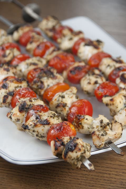 grilled pesto chickene skewers on a white plate