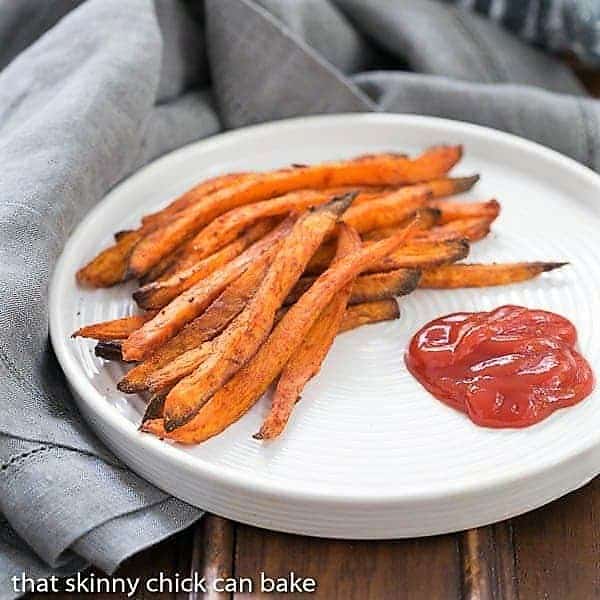 Spicy Sweet Potato Fries served on a white plate with ketchup.