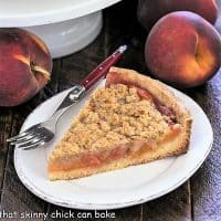 Slice of peach tart recipe on a white ceramic plate