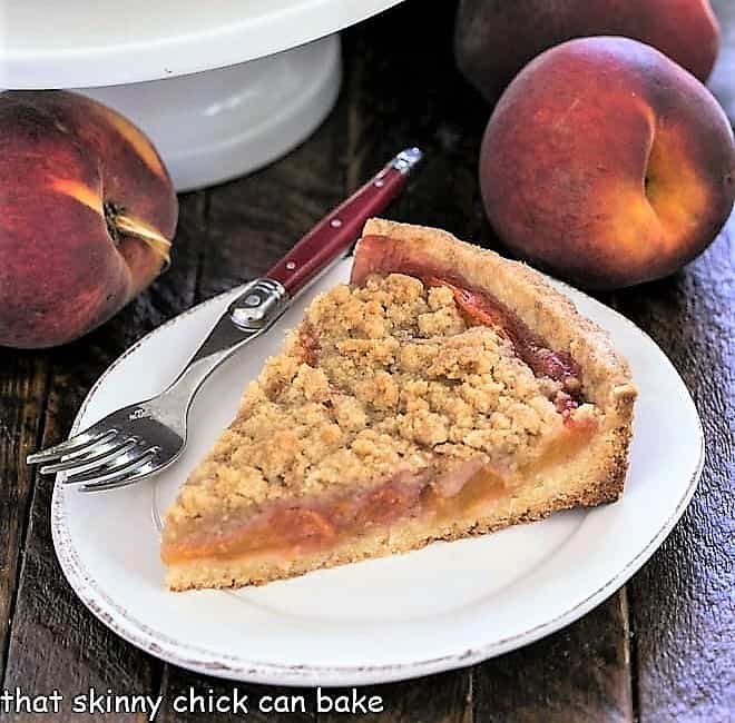 Slice of peach tart recipe on a white ceramic plate