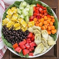 Overhead view of a composed Summer Vegetable Salad in a white bowl