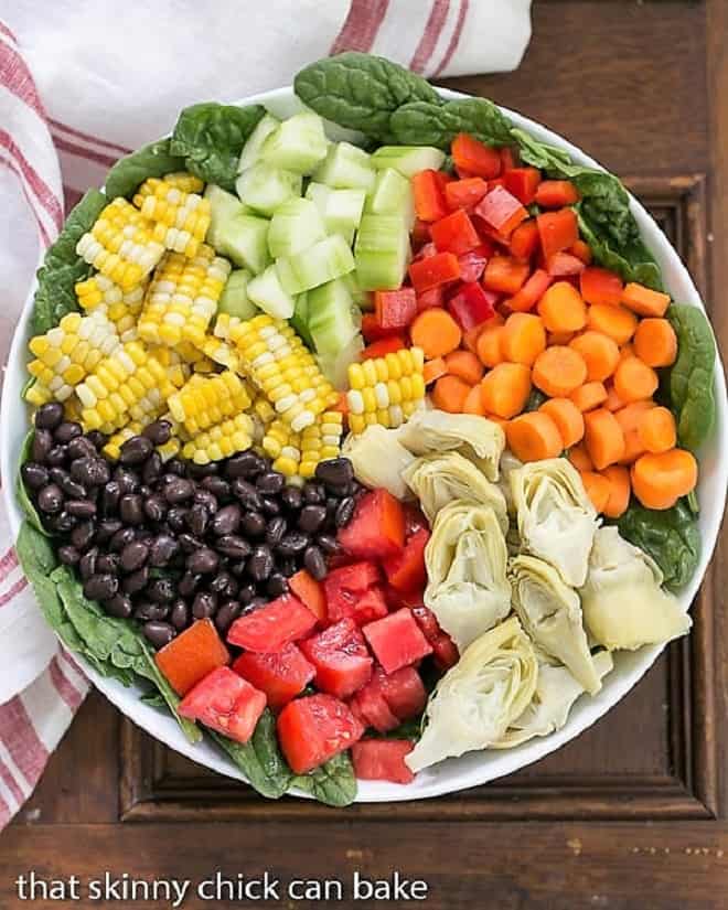 Overhead view of a composed Summer Vegetable Salad in a white bowl.