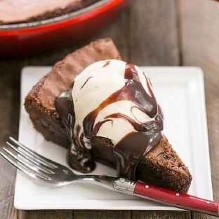 Fudgy Skillet Brownies slice on a square white plate with a red handled fork