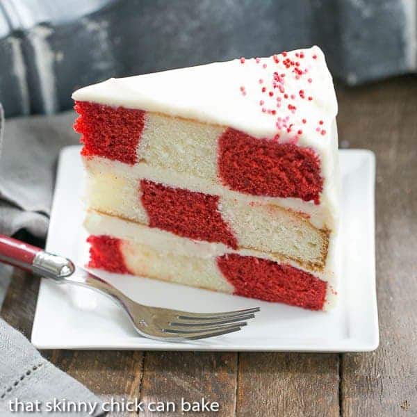 A slice of Red Velvet Checkerboard Cake on a white dessert plate.