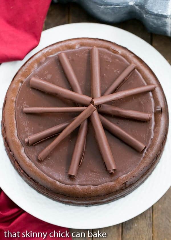 Overhead view of a Triple Chocolate Cheesecake on a white serving plate