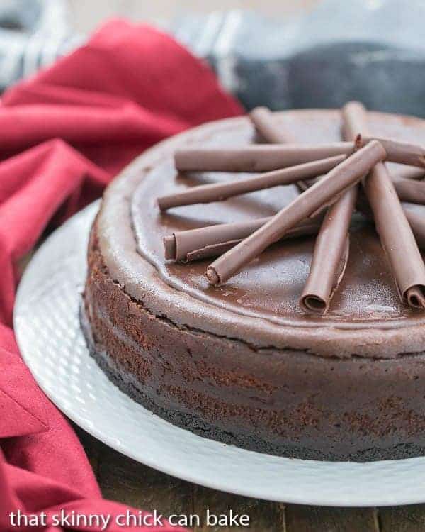 Triple Chocolate Cheesecake on a white ceramic serving plate with a red napkin.