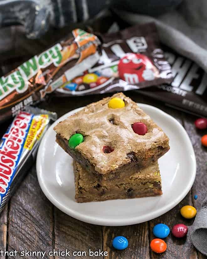 2 Candy Bar Blondies stacked on a small white plate.