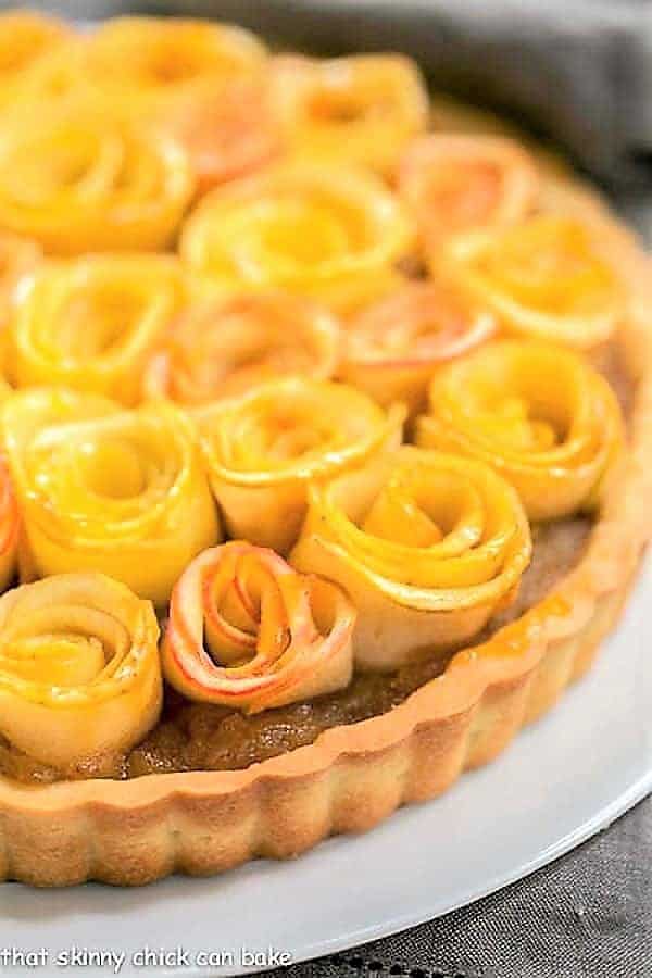 Close up view of Rosette Apple Tart on a white cake plate.