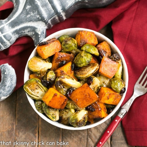 Overhead view of Roasted Autumn Vegetables in a white bowl with a red handled fork.