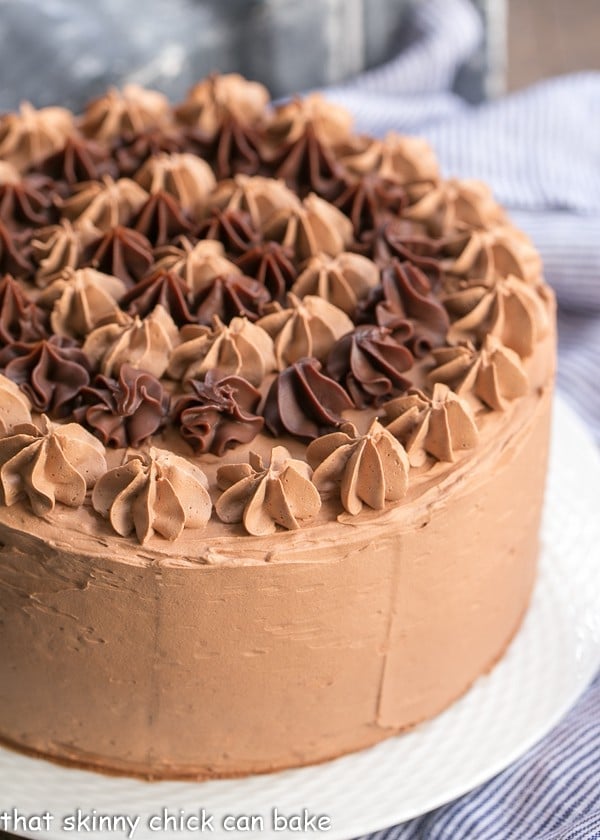 Uncut Chocolate Fudge Layer Cake on a white plate.