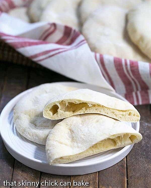 Homemade Pita Bread on a white ceramic plate with once sliced in half.