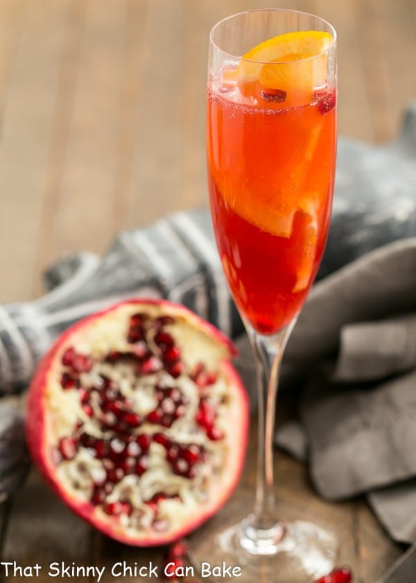 Pomegranate Champagne Cocktail in a champagne flute with a half pomegranate