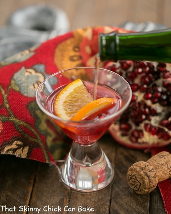 Champagne pouring into a glass of Pomegranate Champagne Cocktail