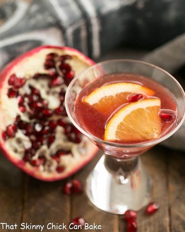 Overhead view Pomegranate Champagne Cocktail  in front of a half a pomegranate.