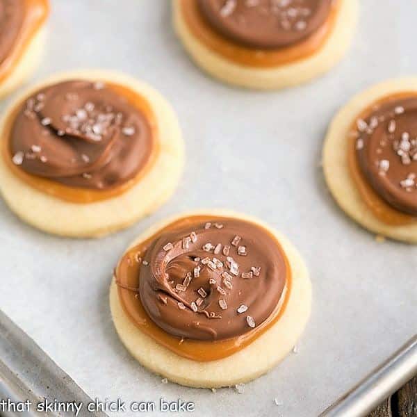 Chocolate Caramel Shortbread Cookies baked and decorated on a parchment-lined sheet pan.