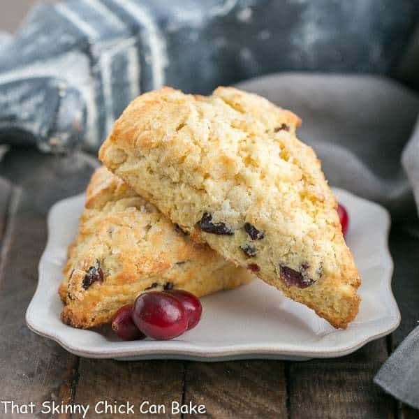 Cranberry Eggnog Scones on a square plate with fresh cranberries.