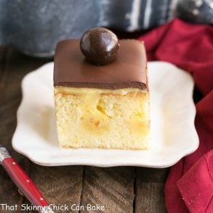 Boston Cream Pie Poke Cake | A moist, buttery cake filled with vanilla pudding and topped with ganache!