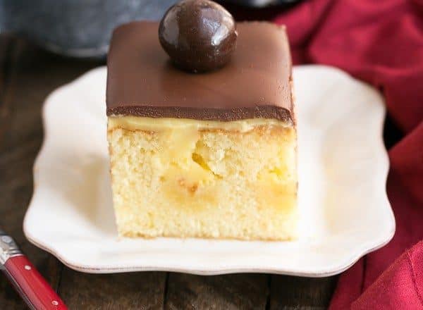 Boston Cream Pie Poke Cake | A moist, buttery cake filled with vanilla pudding and topped with ganache!