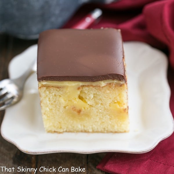 piece of Boston Cream Pie Poke Cake on a white dessert plate