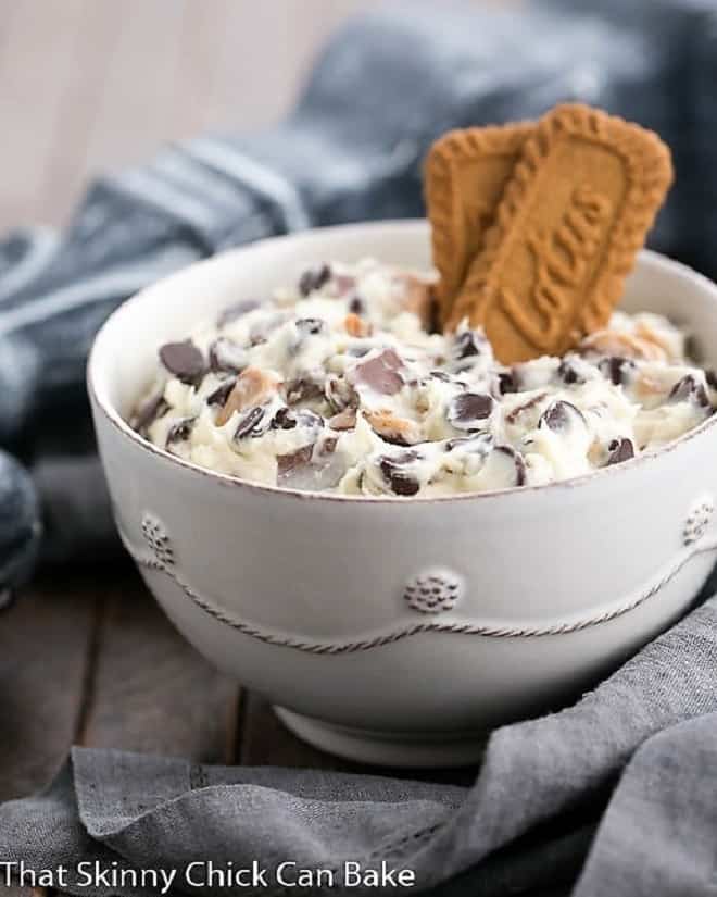 Chocolate Chip Cookie Dough Dip in a white bowl garnished with 2 Biscoff cookies.