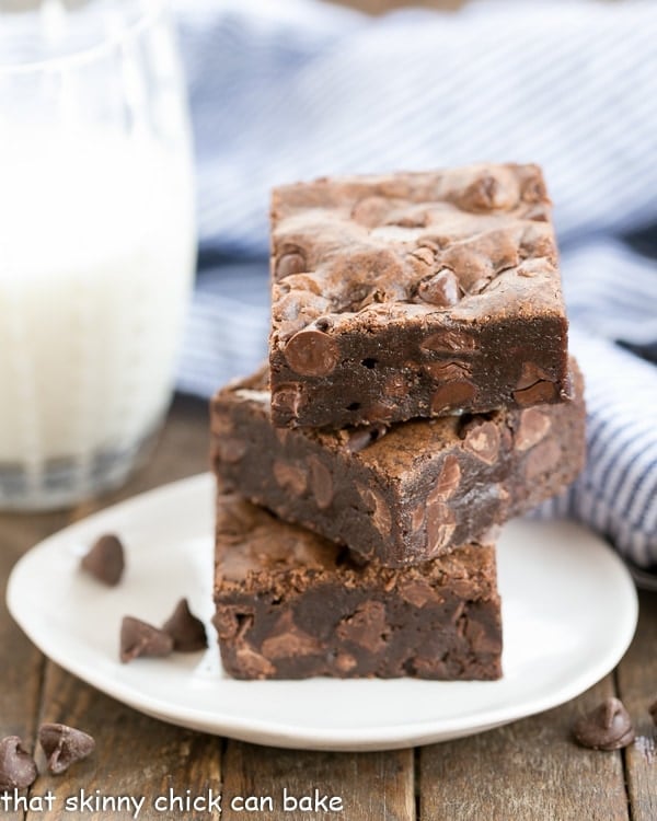 Fudgy Cocoa Brownies stacked on a small white dessert plate.