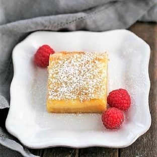 Gooey Butter Bars dessert on a plate with fresh raspberries