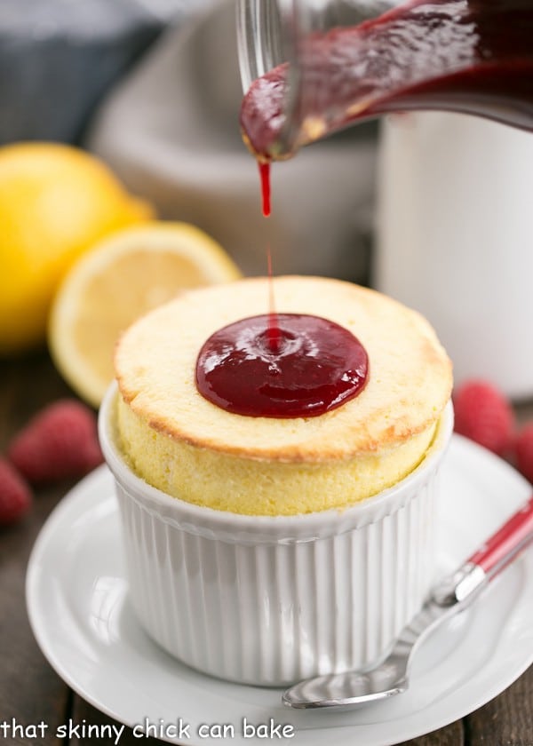 Photo of fresh raspberry sauce being poured onto Lemon Soufflés.