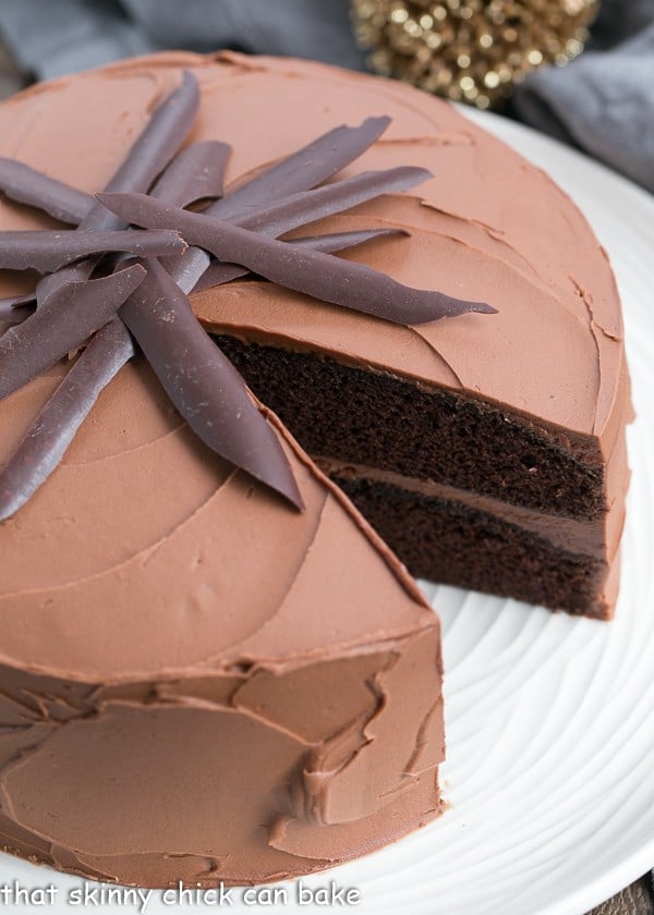 Chocolate Mayonnaise Cake with a slice removed on a white serving plate.