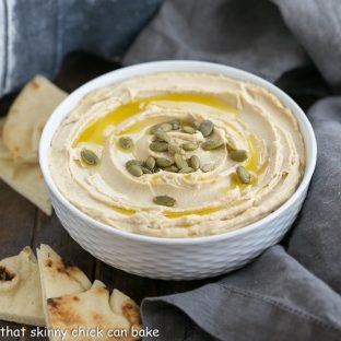 a white bowl filled with creamy hummus from scratch