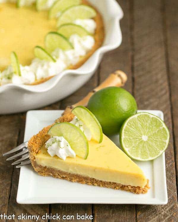 Slice of Key Lime Pie with Graham Cracker Crust on a square white dessert plate.