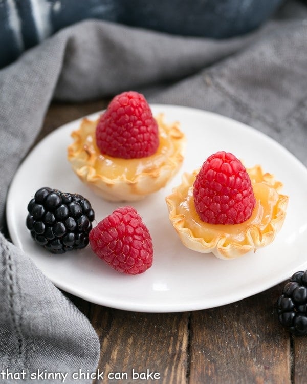 Mini Lemon topped with raspberries on an oval white plate