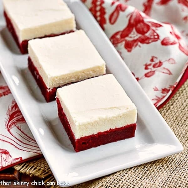 Red Velvet Brownies with White Chocolate Icing on a white rectangular serving tray