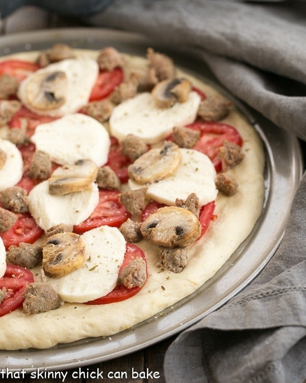 Sausage Mushroom Pizza on a pizza pan ready for the oven.