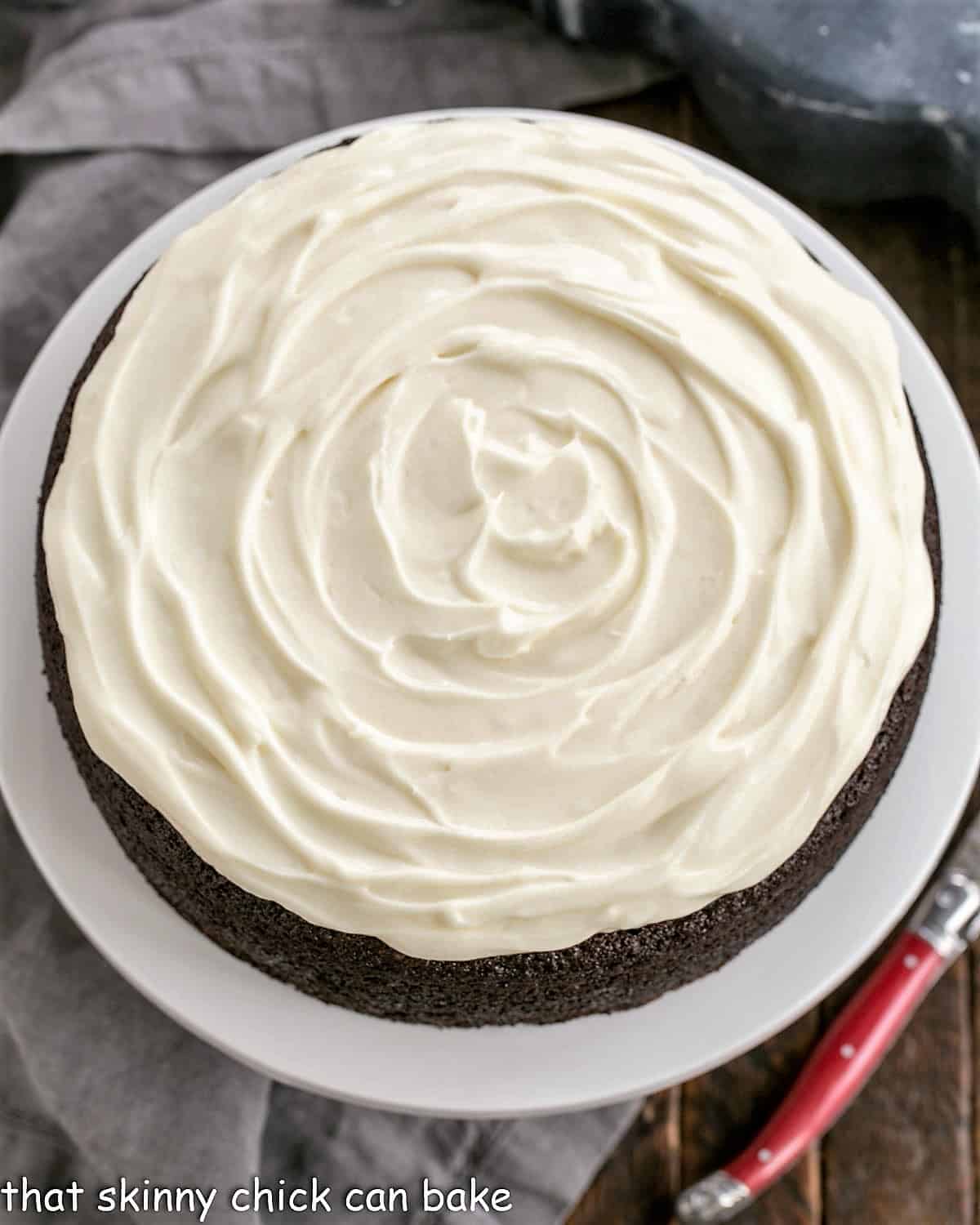 Chocolate Guinness Cake is a rich chocolate cake spiked with Guinness ale and topped with cream cheese icing. This easy chocolate cake recipe is makes the perfect St. Patrick's Day dessert! #stpatricksday #dessertrecipe #chocolate #cake #recipe Overhead image of a cream cheese frosted Guinness infused chocolate cake.