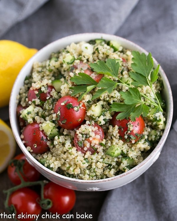 Quinoa tabbouleh is classic Middle Eastern salad updated with the addition of superfood, quinoa. This Quinoa Tabbouleh recipe is sporting a lot of green, making it a healthy option for the St. Patrick's Day dinner table. #sidedish #recipe #quinoa overhead photo of a white bowl filled with tabbouleh, made with quinoa instead of bulgar