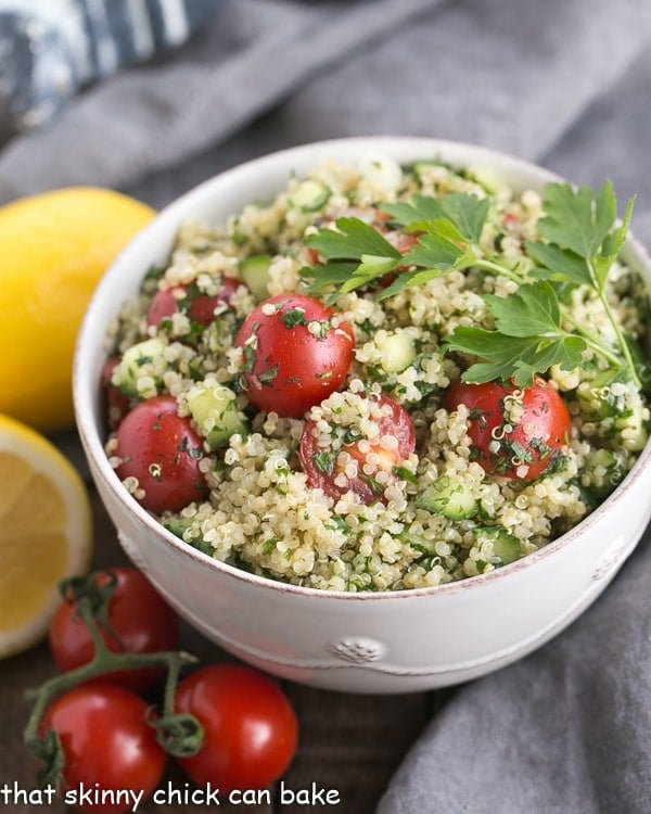 Quinoa tabbouleh recipe is classic Middle Eastern salad updated with the addition of superfood, quinoa. This Quinoa recipe is sporting a lot of green, making it a healthy option for the St. Patrick's Day dinner table. #sidedish #recipe #quinoa white bowl of Qunioa Tabbouleh