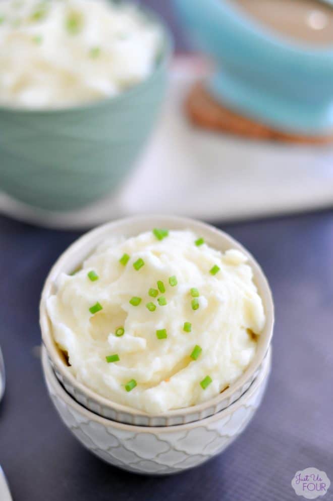 Mascarpone mashed potatoes in a small bowl garnished with chives