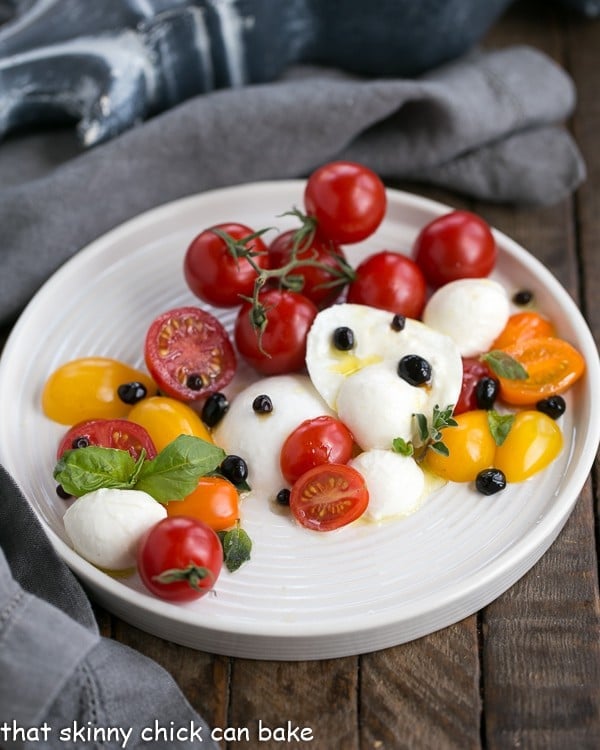 An arranged Burrata Caprese Salad on a white ceramic plate