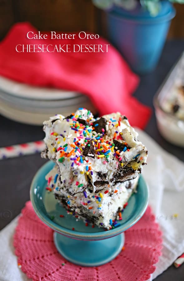 Slices of cake batter oreo cheesecake on a teal stand