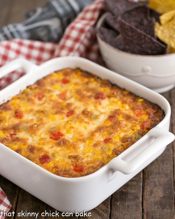 Fiesta Corn Dip - With a double dose of gooey cheese, you'll want to serve this magnificent dip at every gathering! Fiesta Corn Dip in a square white casserole dish.