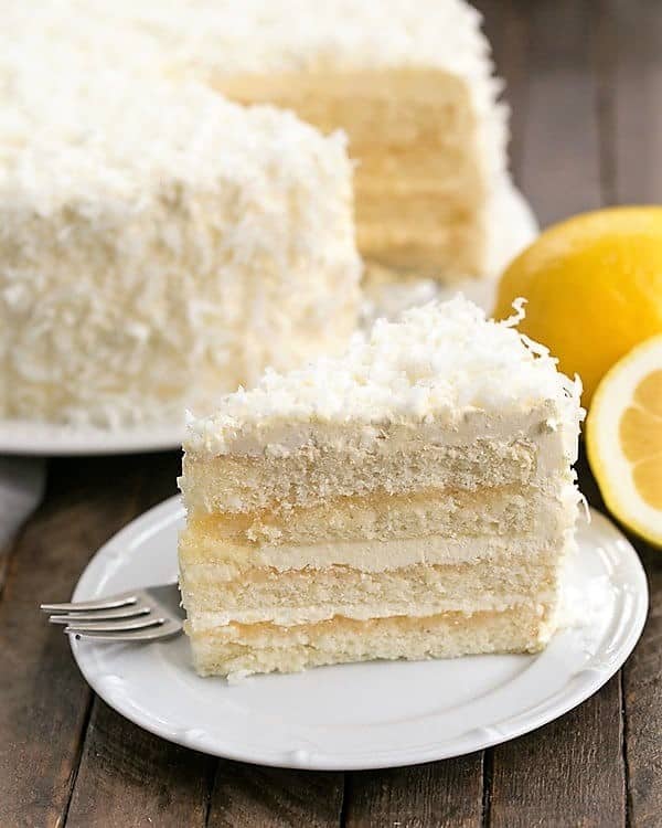 Lemon Layer Cake with Lemon Curd Filling slice on a white dessert plate.