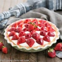 Strawberry Cream Pie in a cerami pie plate surrounded by fresh strawberries